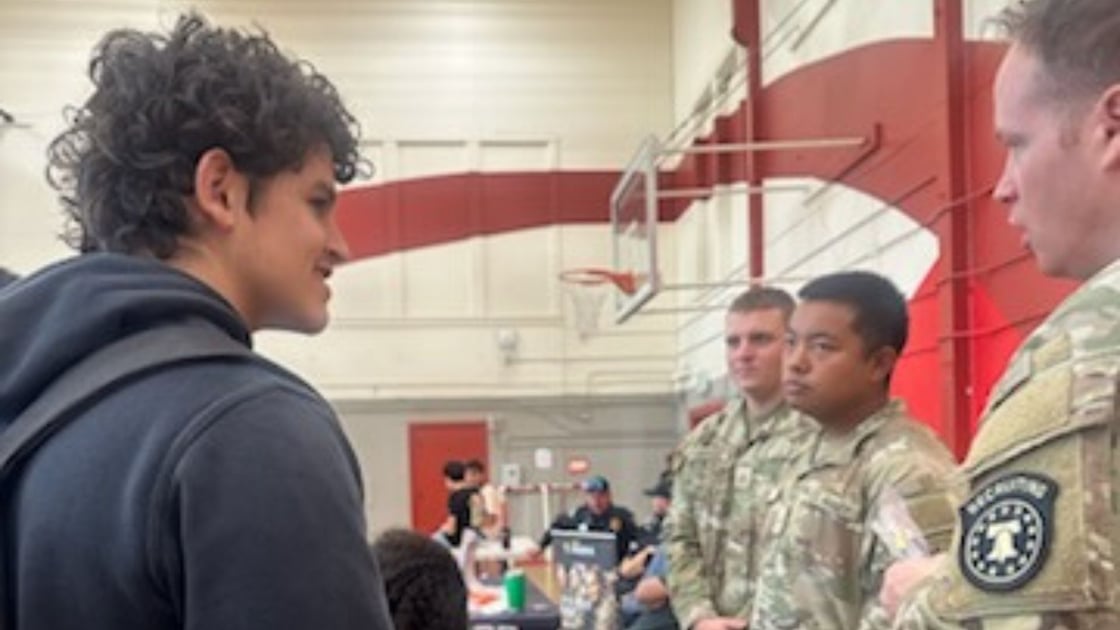Sebastian C. chats with military personnel at San Juan High's career day, seeking opportunities for self-discipline and lifelong memories.