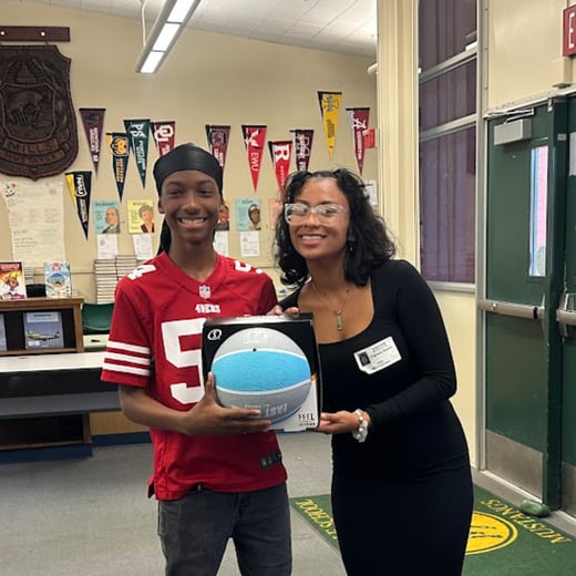 Jayden Mitchell, a 7th grader, is posing with this prize for academic achievement. He received a basketball.