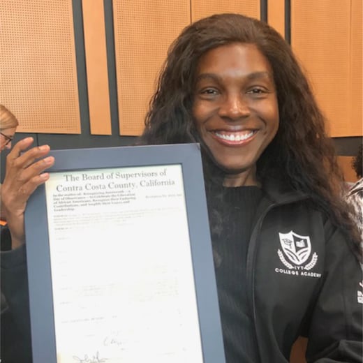 Dr. Erica Conners is holding a framed document recognizing June 19th (Juneteenth) as an official holiday.